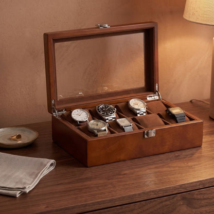 Le Comptoir X ambre ouvert sur une commode en noyer, montres posées sur leurs coussins