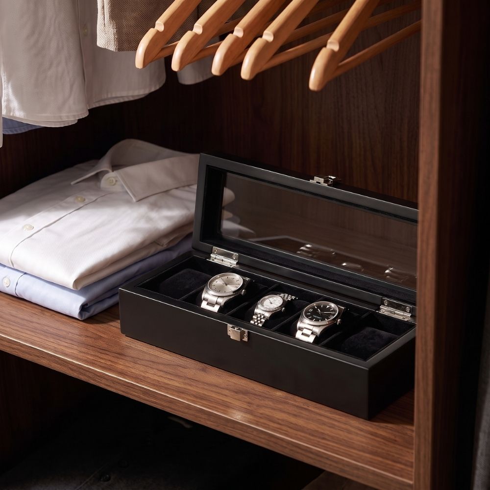 Le Comptoir V noir ouvert sur une étagère de dressing, à côté de chemises pliées