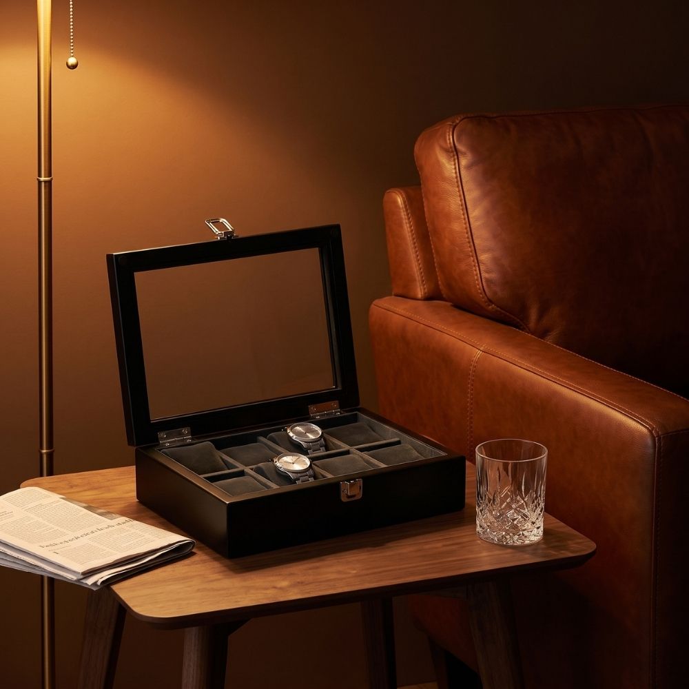 Le Comptoir VIII noir ouvert sur une table d'appoint, deux montres posées sur leurs coussins