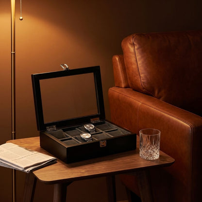 Le Comptoir VIII noir ouvert sur une table d'appoint, deux montres posées sur leurs coussins