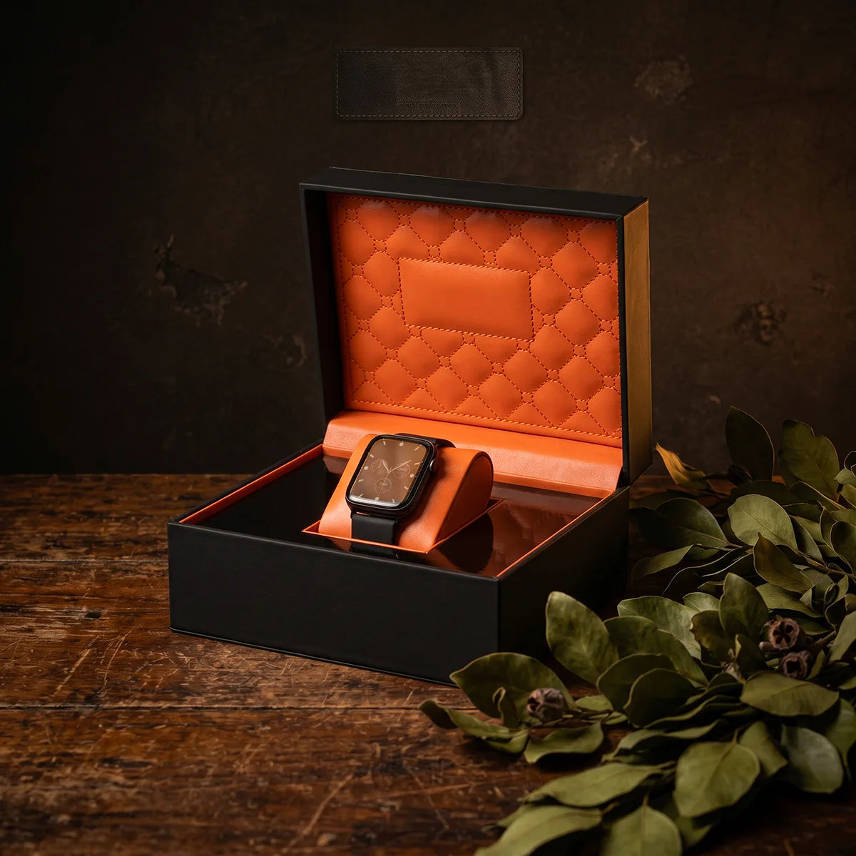 Boîte à montre 1 pièce Le Capiton ouvert sur une table en bois. Une montre noir à l'intérieur