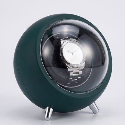 La Capsule, remontoir de montre automatique vert bouteille, capot ouvert avec montre à l'intérieur