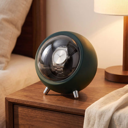 Remontoir de montre La Capsule vert bouteille sur une table de nuit, lumière chaude du soir