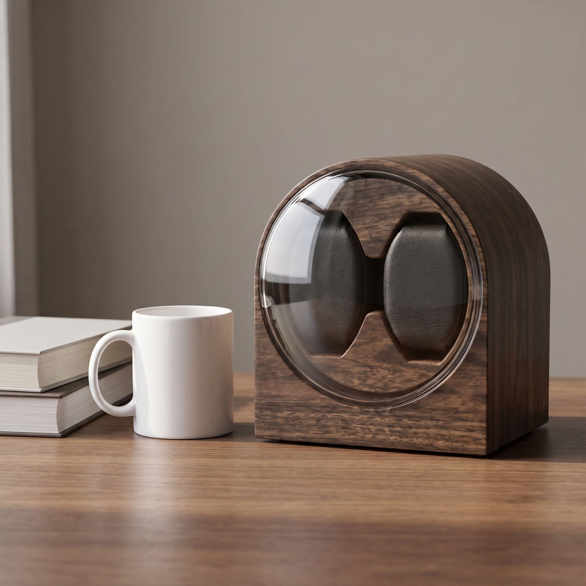 Taille du remontoir L'Arche Duo comparée à un mug et deux livres posés sur un plateau en bois