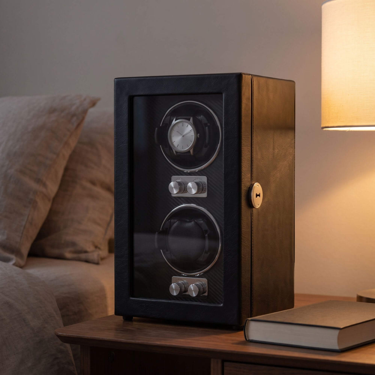 Le Coffre sur une table de chevet, une montre automatique en place derrière la porte vitrée