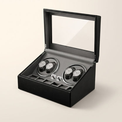 Coffret remontoir 4 montres en similicuir noir à couvercle vitré, ouvert sur fond ivoire
