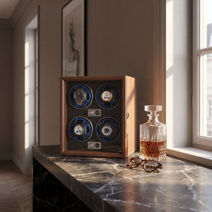 Remontoir 4 montres posé sur une console en marbre, à côté d'une carafe en cristal