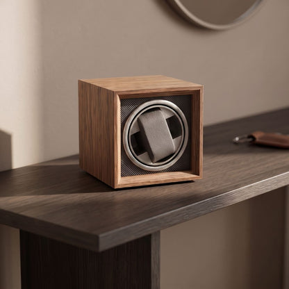 Remontoir L'Anthracite posé sur une console en bois foncé dans une entrée